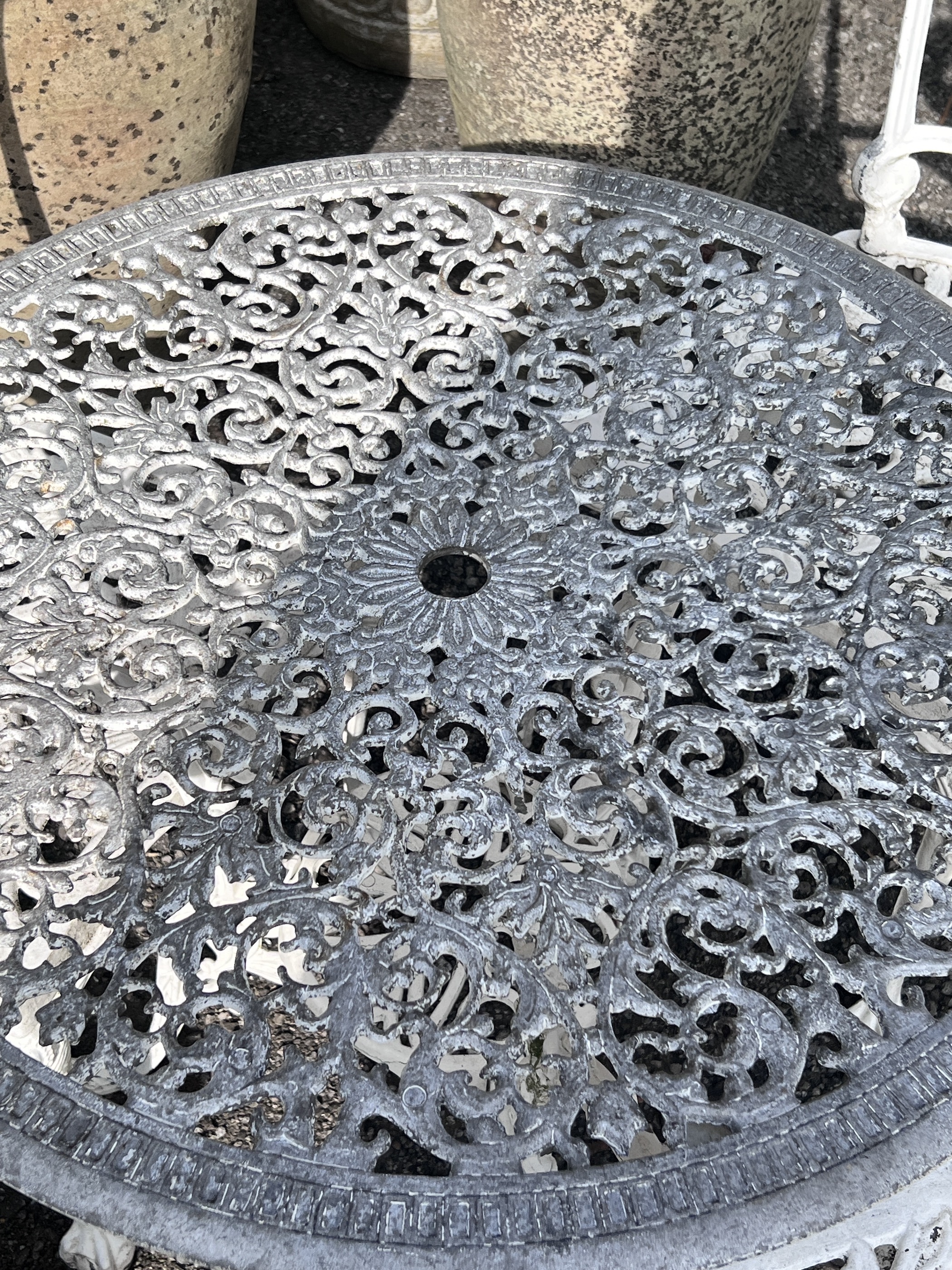 A Victorian style circular painted aluminium garden table, diameter 72cm, height 65cm, and three chairs